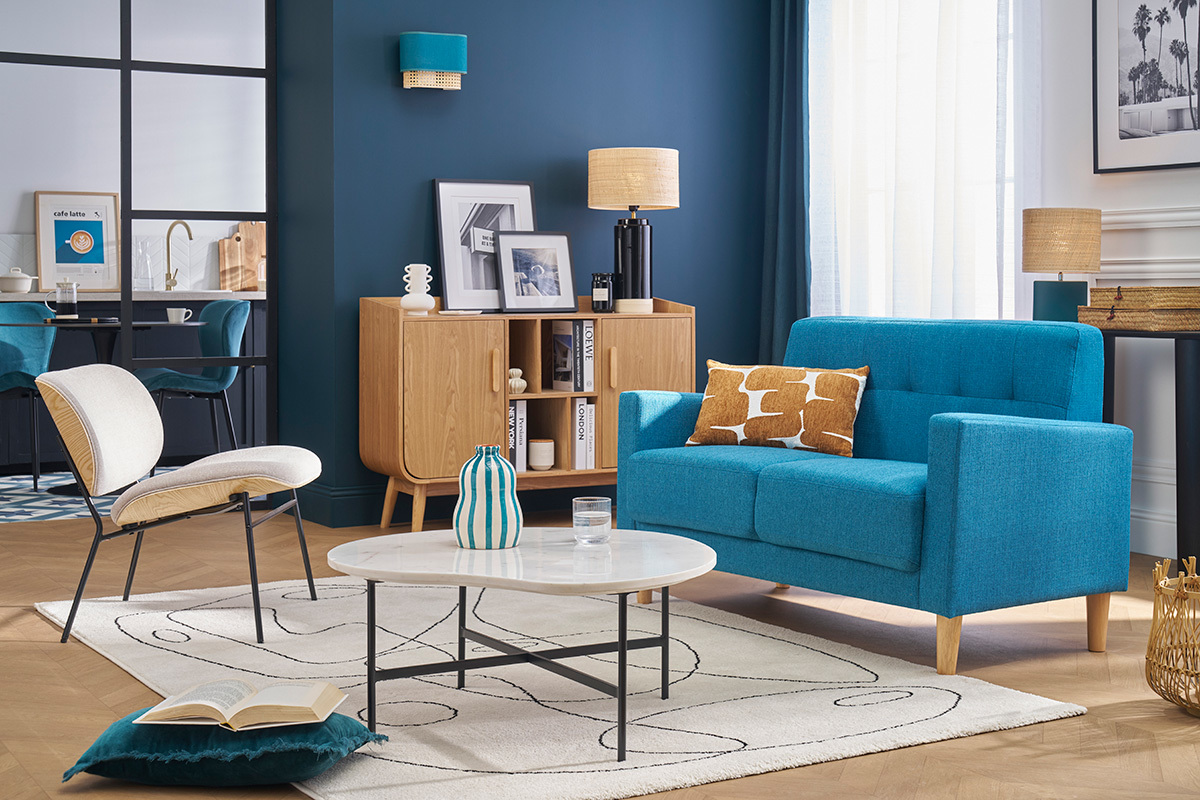 Skandinavisches Zweisitzer-Sofa in Petrolblau, Stoff und hellem Holz MOON, Gesamtansicht in einem Wohnzimmer.