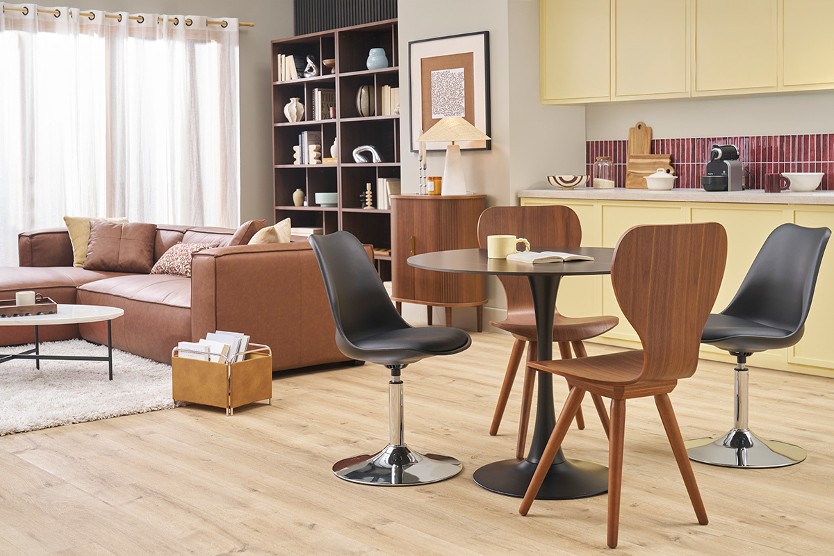 Vintage dunkelholzene Walnussst�hle um einen schwarzen runden Tisch in einem modernen Wohnzimmer.