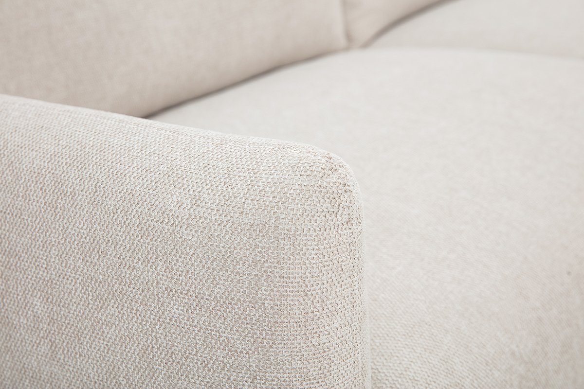 Nahaufnahme des beige texturierten Samteffektstoffes eines Sofas.
