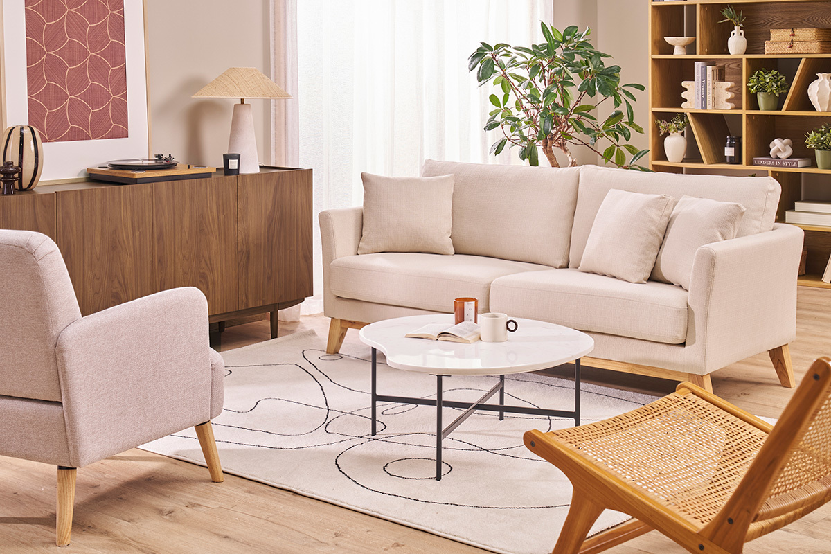 Skandinavisches 3-Sitzer-Sofa in Beige, mit hellen Holzbeinen, mit Kissen in modernem Wohnzimmer.