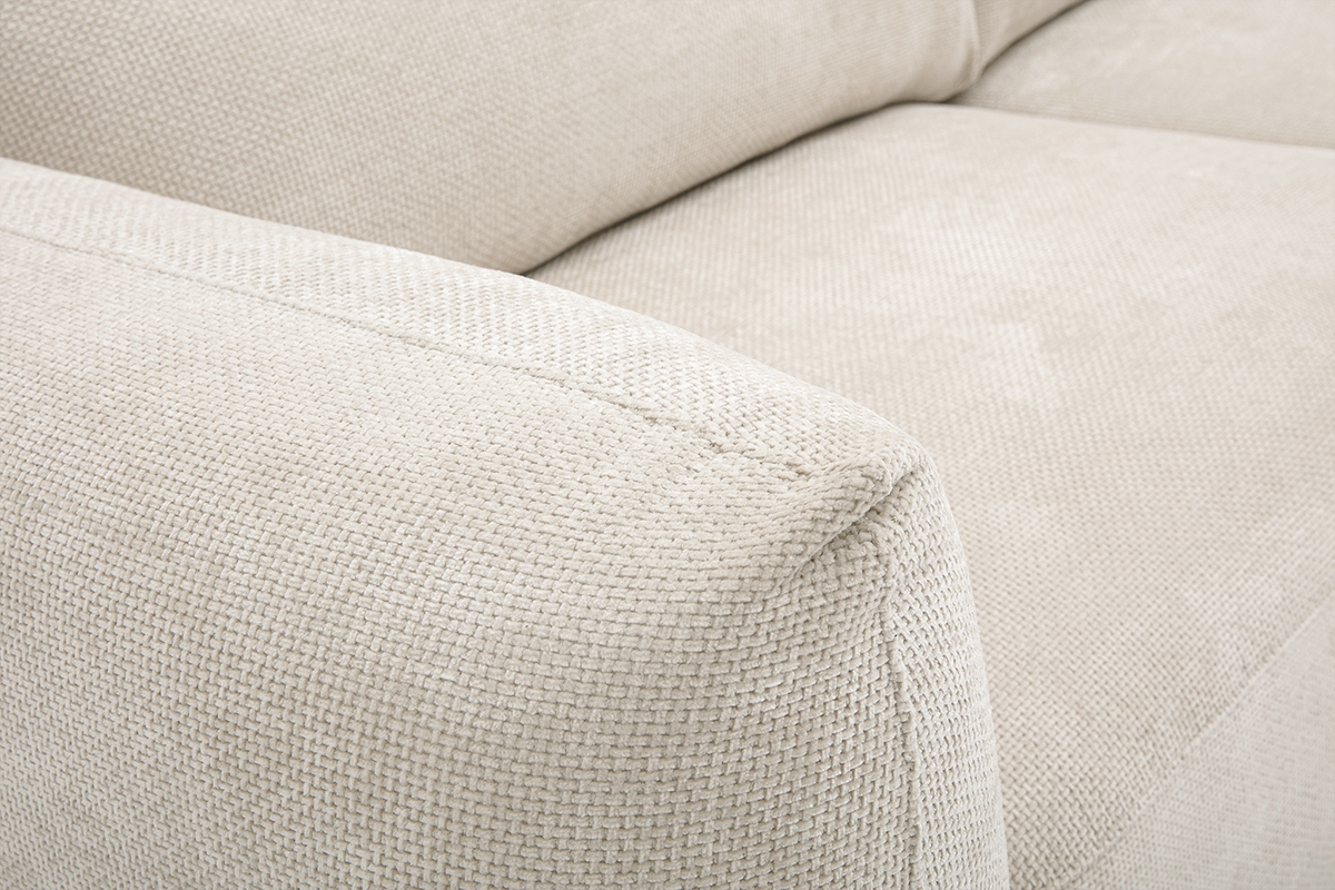 Nahaufnahme der Armlehne eines Sofas aus beigefarbenem Chenille-Samtstoff.