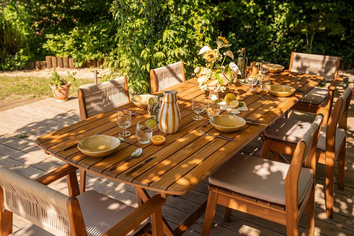Ausziehbarer Gartentisch aus Massivholz, Draufsicht mit Tellern und Gl�sern, bereit f�r eine Mahlzeit.
