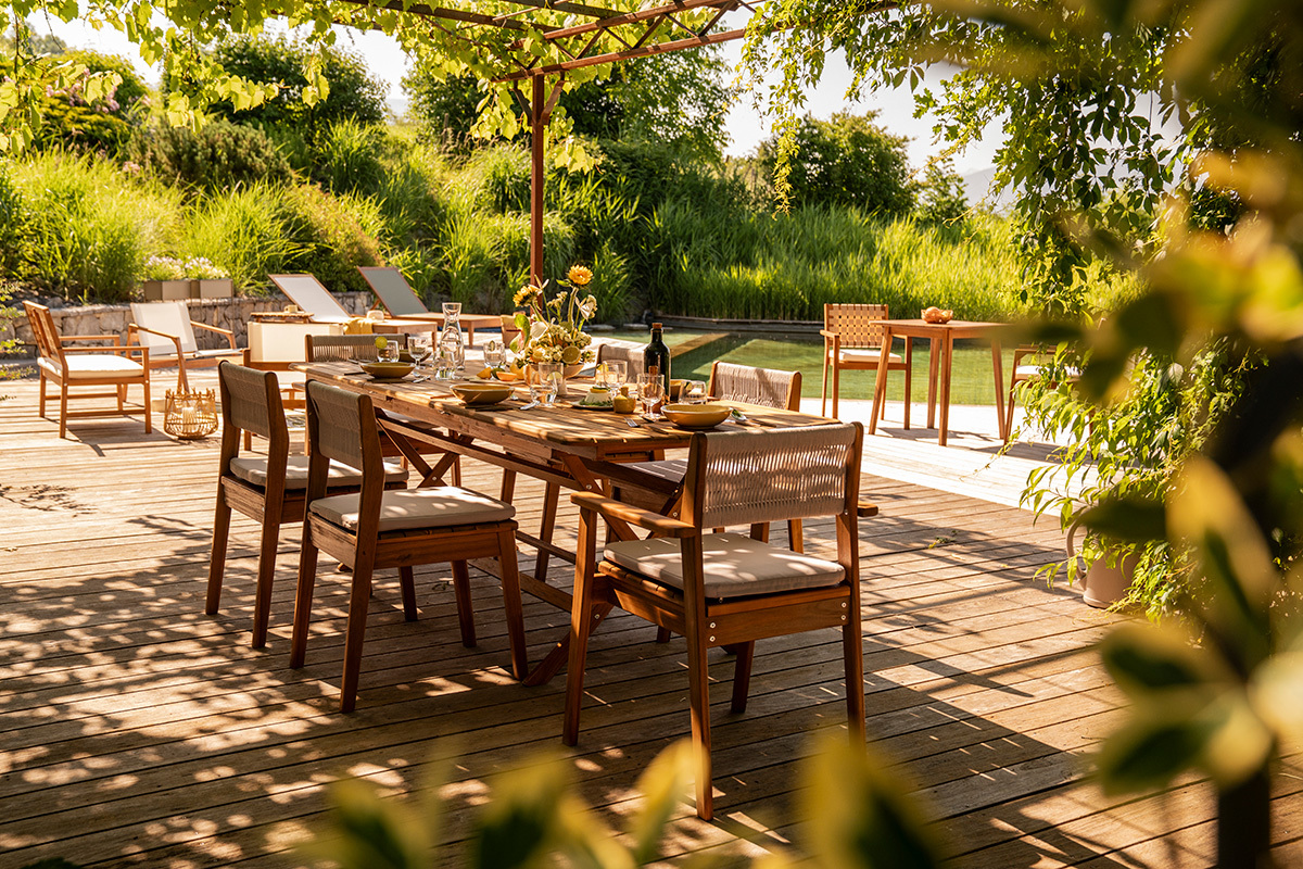 Ausziehbarer Gartentisch aus Massivholz mit St�hlen, Teilansicht einer sonnigen Terrasse