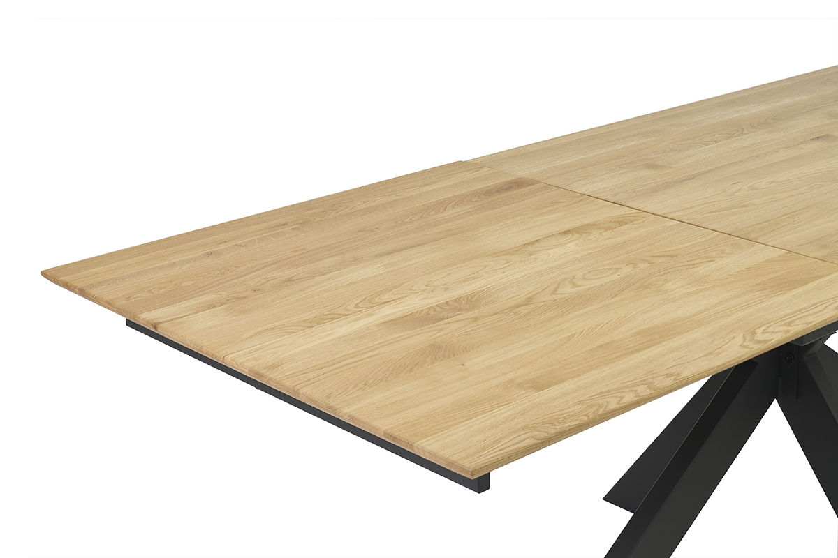 Ausziehbarer Esstisch aus hellem Eichenholz in Eckansicht, teilweise sichtbare integrierte Verlngerung.