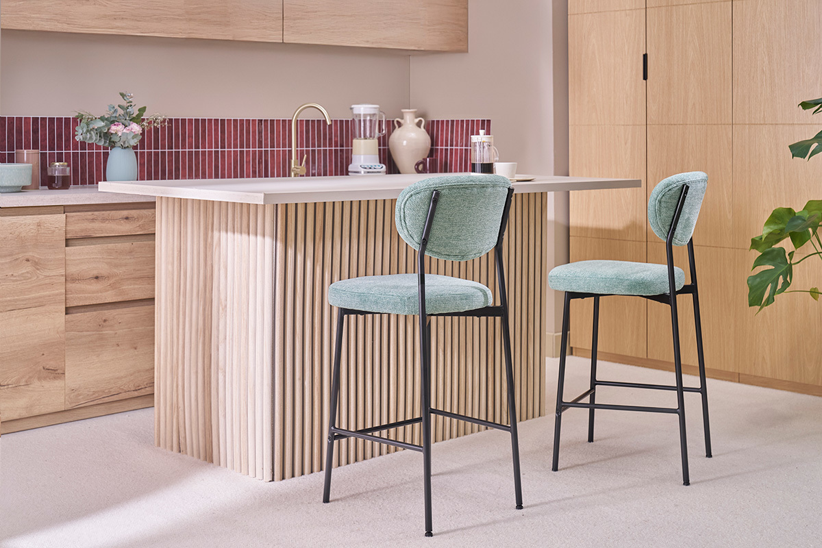 Zwei gr�ne Barhocker aus C�ladon-Samtstoff und schwarzem Metall vor einer K�cheninsel.
