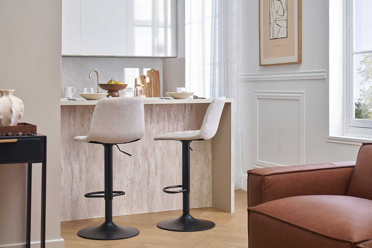 Zwei einstellbare Barhocker in Beige und Schwarz, im Profil, vor einem Tresen.