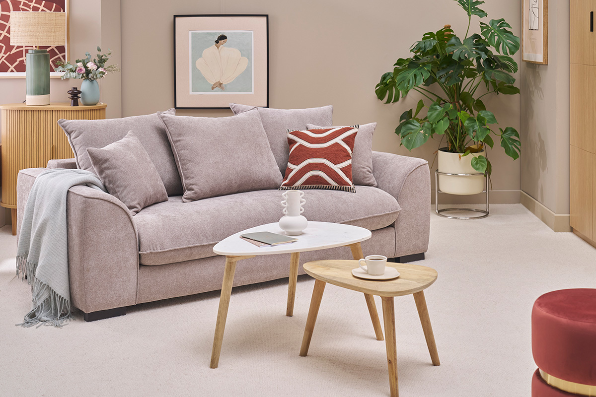Nesting-Beistelltische aus Marmor und Holz vor einem beigen Sofa in einem eleganten Wohnzimmer.