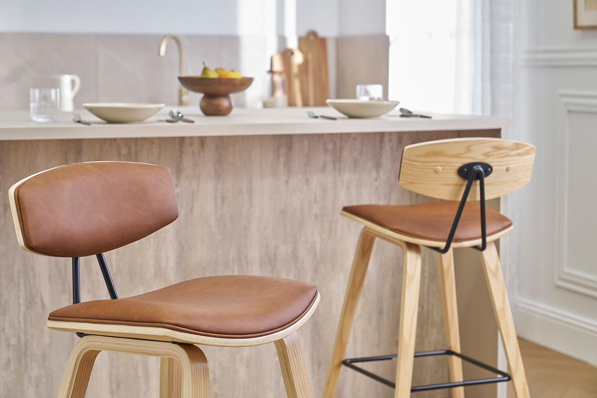 Zwei Designer-Barhocker in Braun und hellem Holz vor einer Kchenbar.