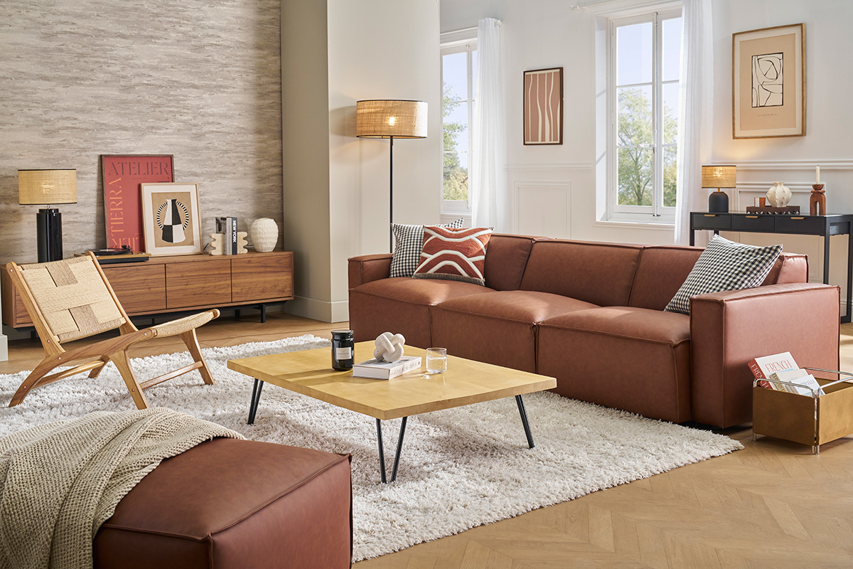 Wohnzimmer mit rechteckigem Mangoholz-Couchtisch und Ledersofa.