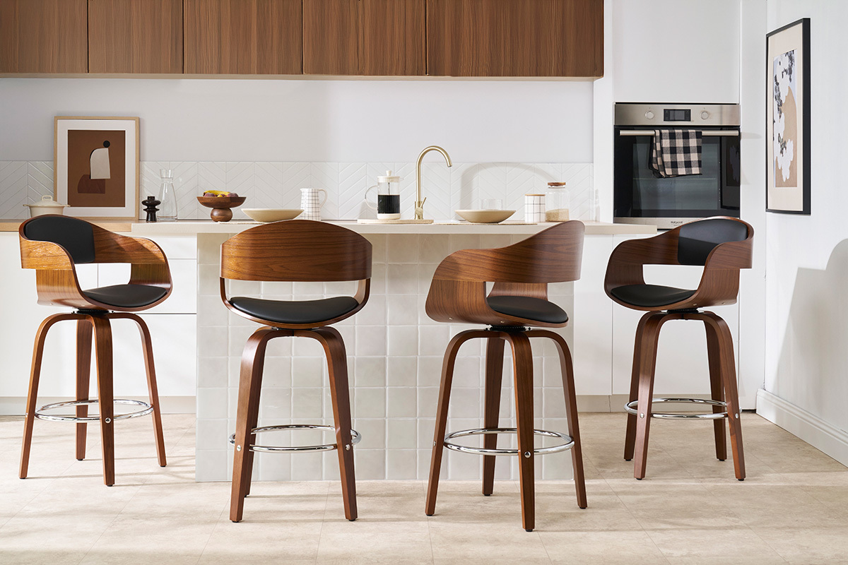 Vier dunkle Holz- und schwarze Barhocker vor einer K�cheninsel.