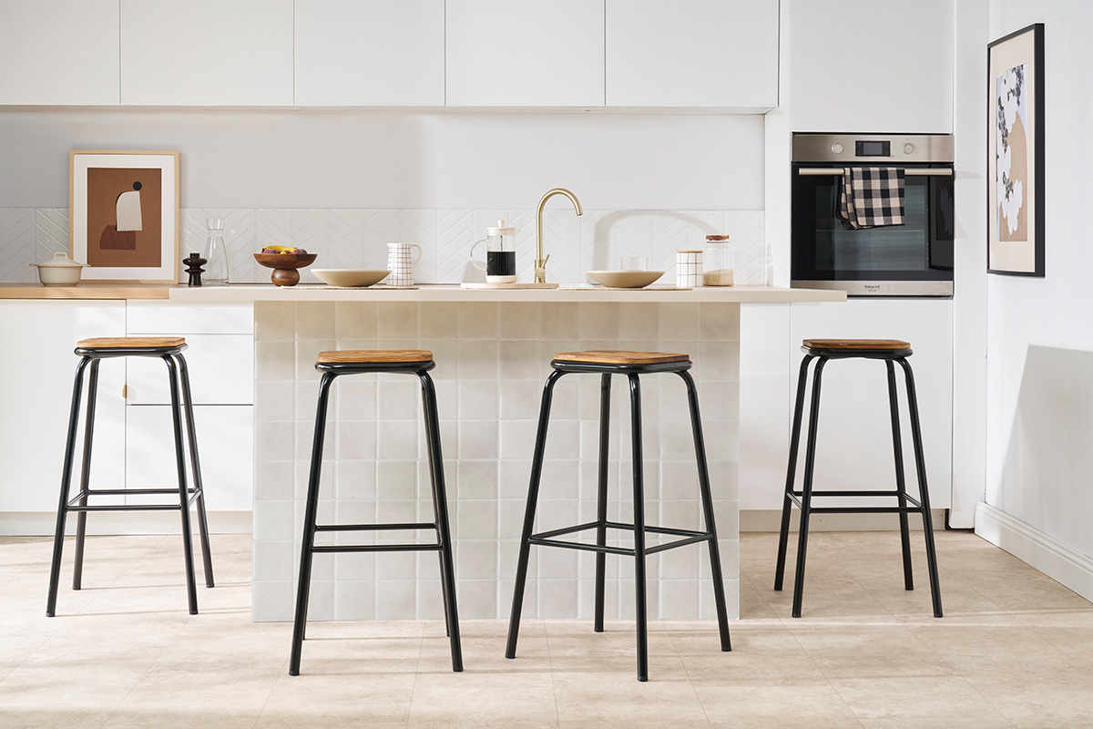 Hocker MEMPHIS schwarz und dunkles Holz vor einer Kcheninsel.