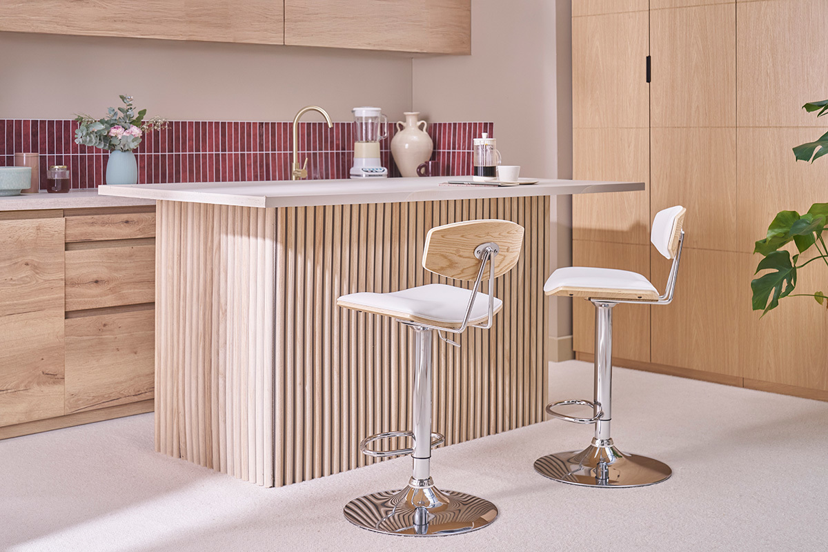 Einstellbare Barhocker in Wei� und hellem Holz vor einer Theke in einer modernen K�che.