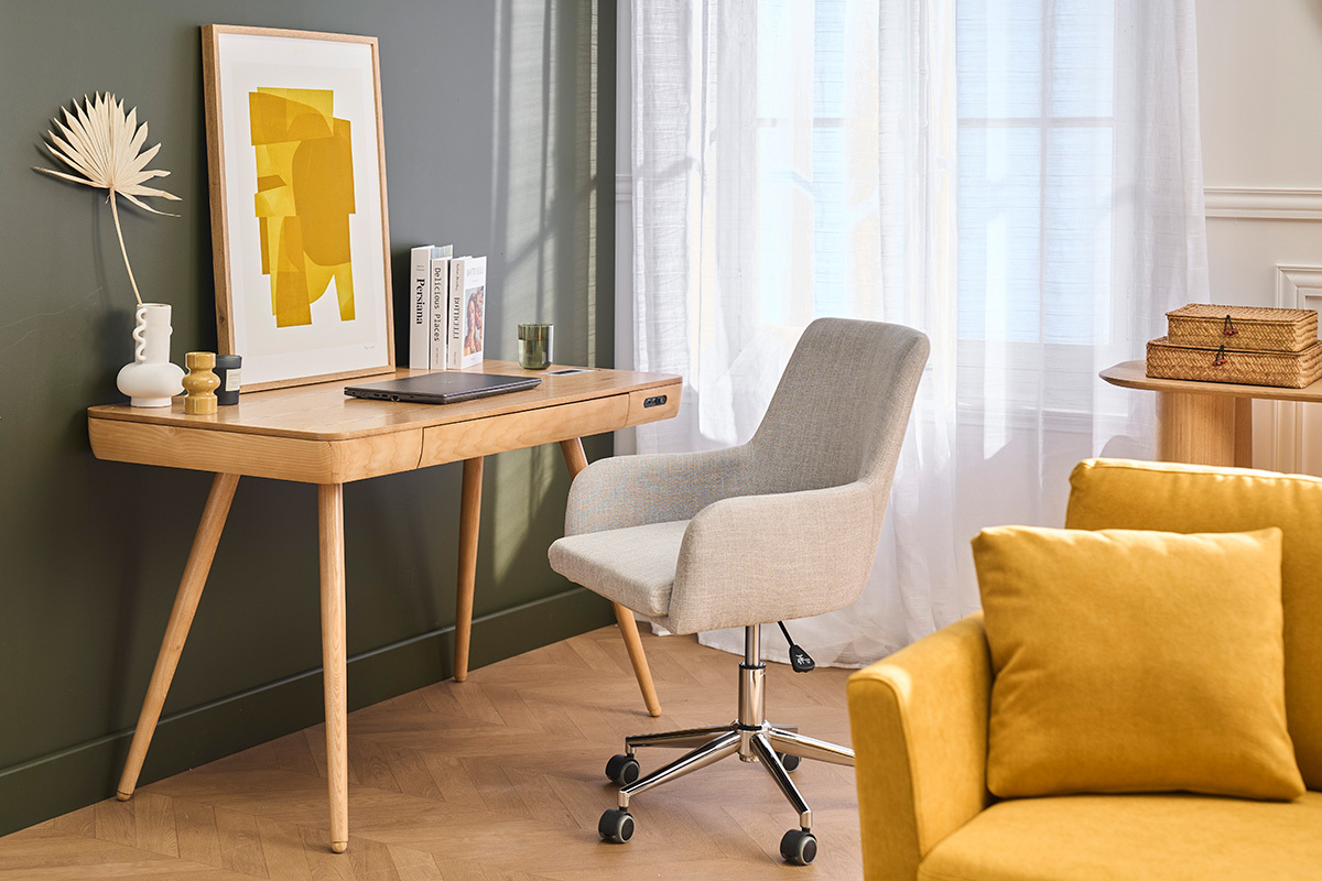 SHANA hellgrauer Stoffb�rostuhl vor einem Holzschreibtisch, neben einem gelben Sofa.