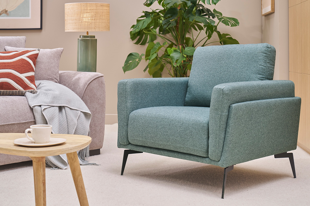 Gr�ner Design-Sessel MOSCO mit schwarzer Metallstruktur, gesehen in einem Wohnzimmer.