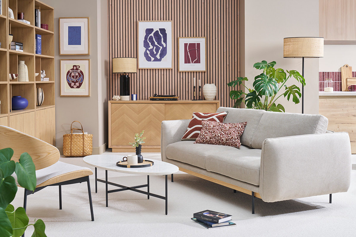 Design-Sofa mit 3 Pl�tzen aus beigefarbenem Chenille-Stoff, schr�g vor einer modernen Kulisse.