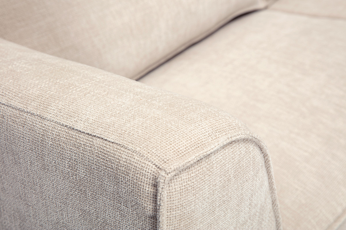 Detail eines 3-Sitzer-Designsofas aus beigem Stoff mit strukturierter Samtoptik, Nahaufnahme der Armlehne.