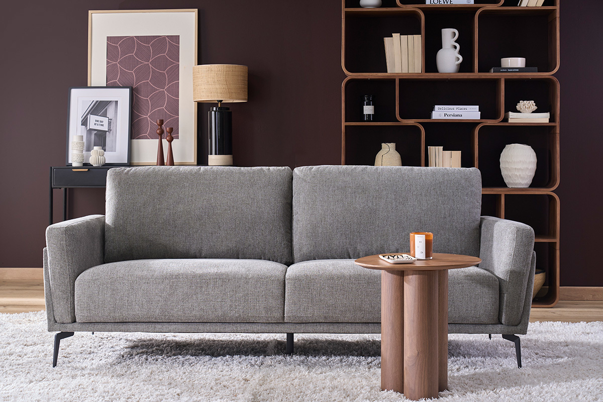 Design-Dreisitzer-Sofa aus grauem Samtstoff, Frontansicht mit Dekorationstisch