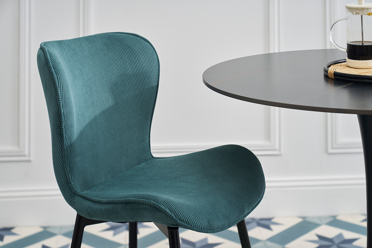 Designersessel aus blauem Cord mit schwarzen Metallbeinen, Seitenansicht.