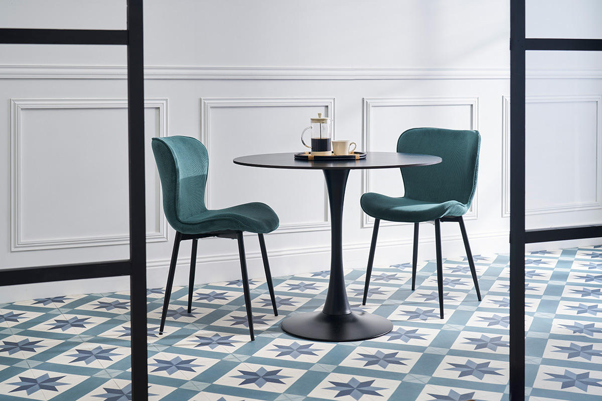 Zwei Entenblau Cord-Sessel mit schwarzen Metallbeinen um einen schwarzen Tisch.