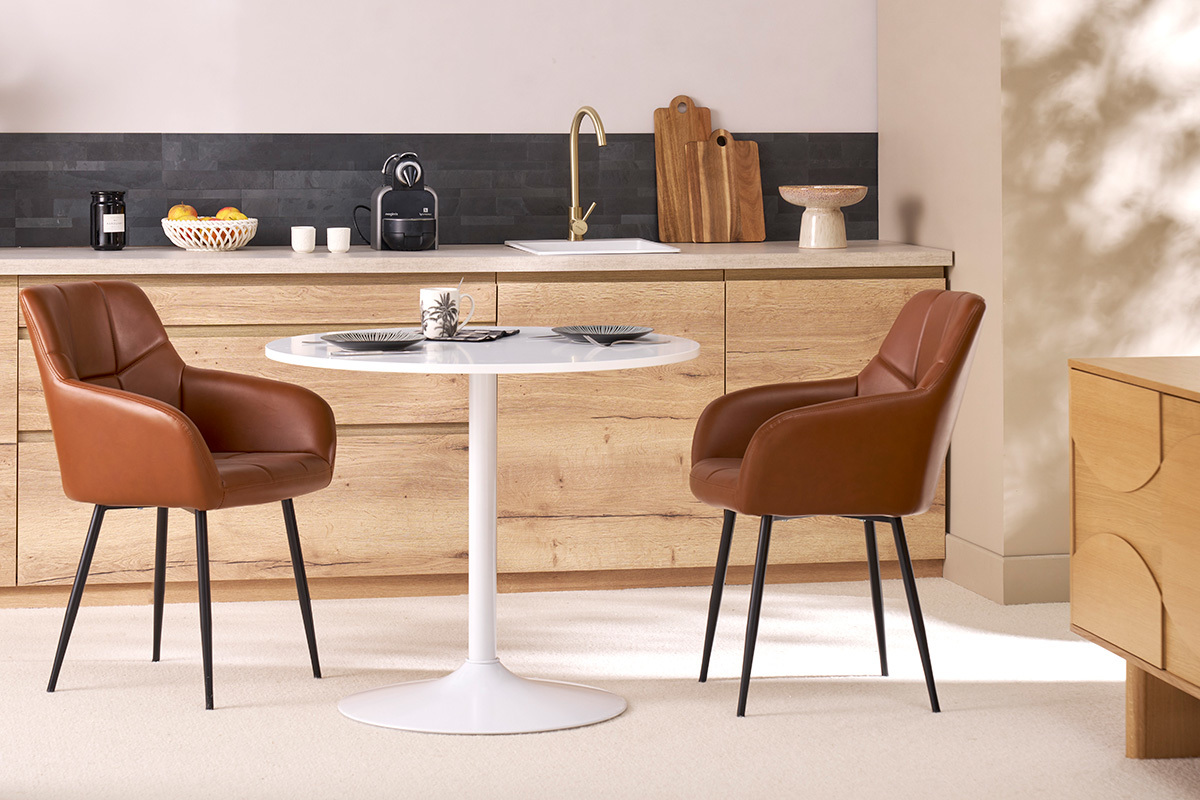 Braune gepolsterte St�hle und schwarzes Metall MONTERO um einen wei�en Tisch.