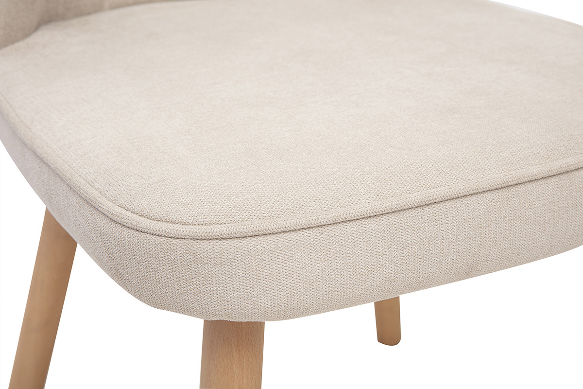 Nahaufnahme des Sitzes eines Stuhls aus beigefarbenem Samtstoff mit hellen Holzbeinen.