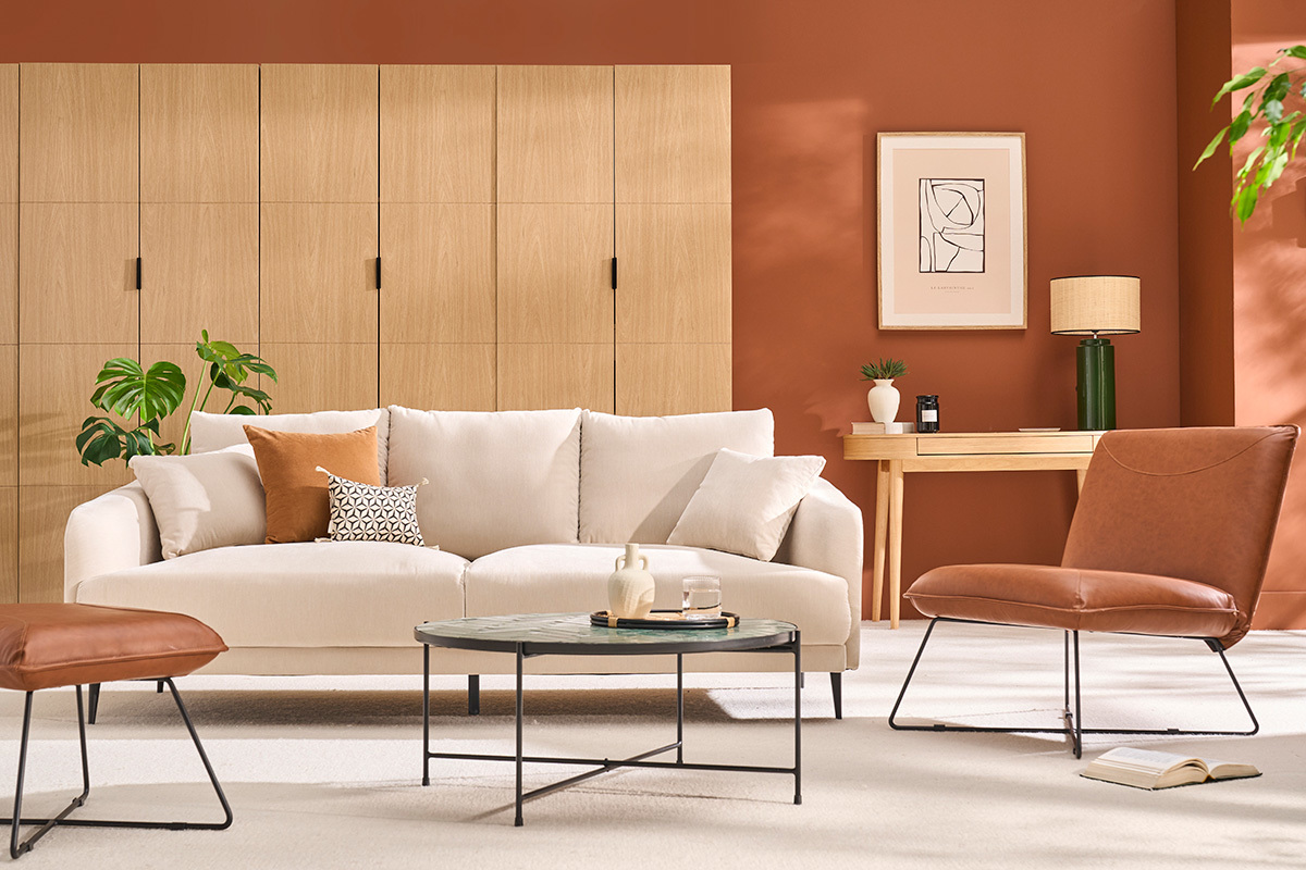 Designsofa f�r 3 Personen aus Stoff mit Kissen und Armlehnen, in einer Gesamtansicht in einem modernen Wohnzimmer.