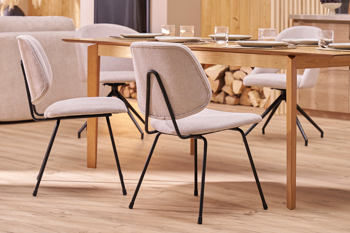 Designerst�hle aus beigem Stoff und schwarzem Metall, Vorderansicht, um einen Holztisch herum.