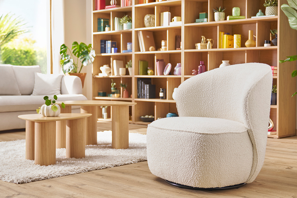 Wei�er drehbarer Design-Sessel, Seitenansicht in einem hellen und modernen Innenraum.