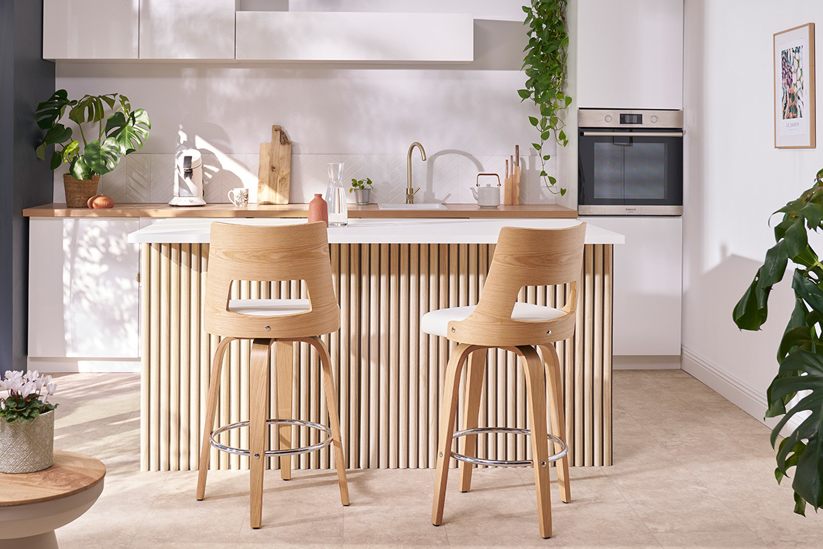 Skandinavischer Barhocker in Wei� und hellem Holz, von hinten in einer modernen K�che gesehen.