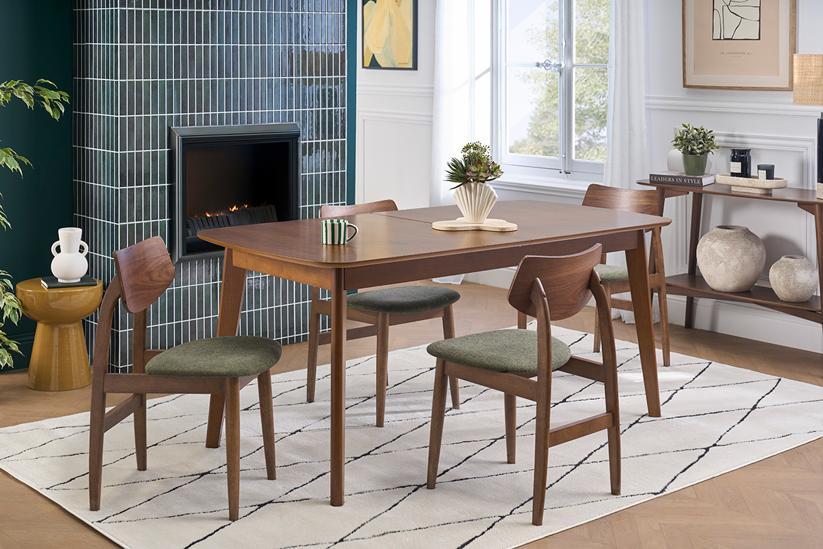 Skandinavische St�hle aus dunklem Holz und gr�nem Kaki-Samtstoff um einen Tisch in einem modernen Interieur