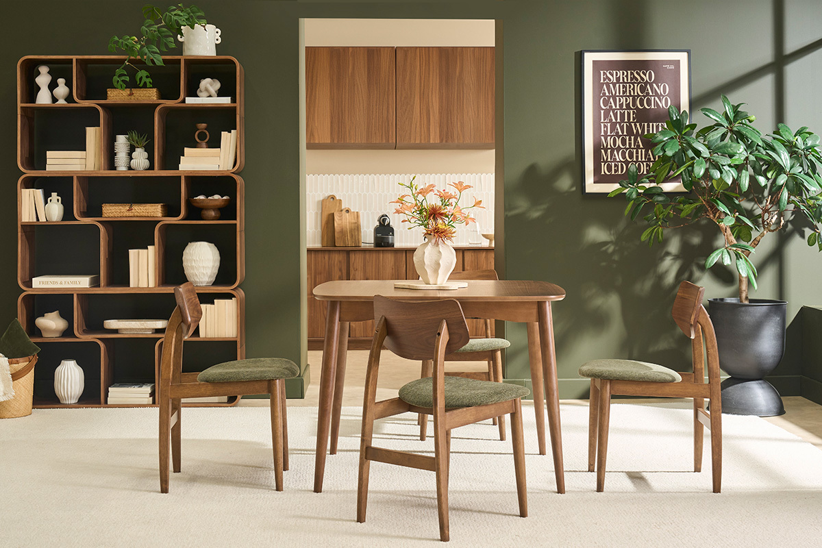 Skandinavische St�hle aus dunklem Holz und gr�nem Samtstoff um einen Tisch in einem modernen Innenraum.