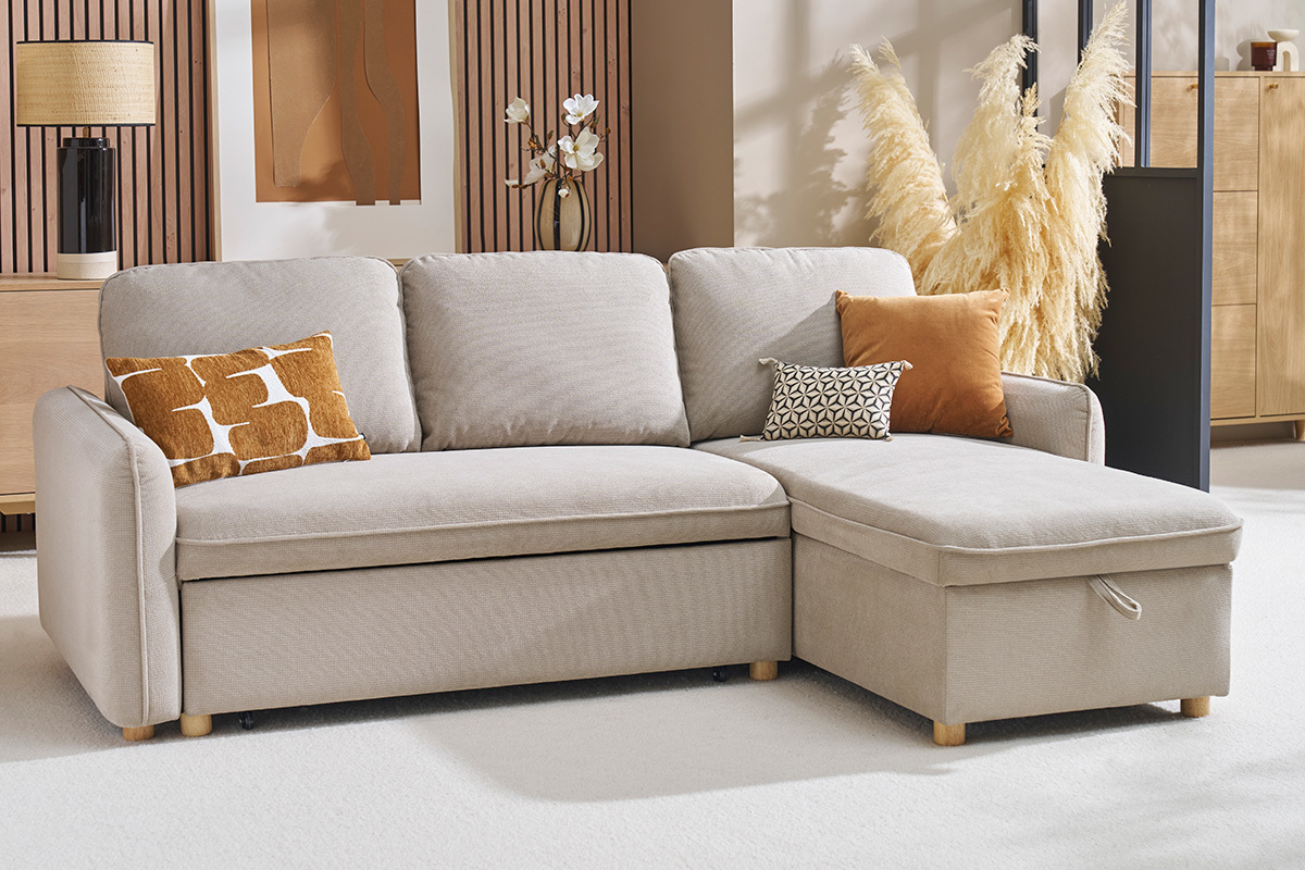 Ecksofa umbaubar 3-Sitzer in beige Stoff mit Kissen auf weiem Teppich.