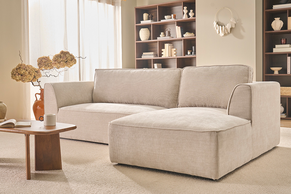 Dreisitziges Ecksofa in einem Wohnzimmer mit Holzregal.