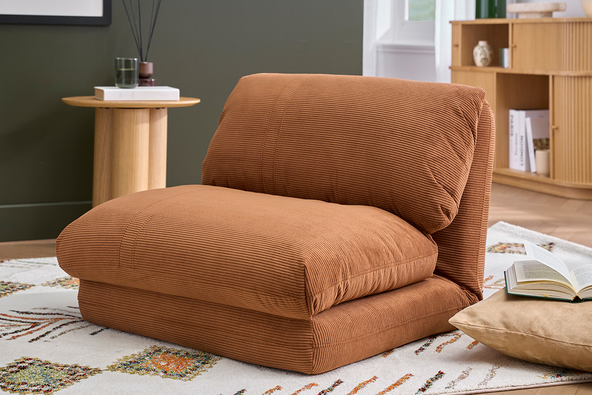 SPENCER Sessel in geripptem Samtstoff in gebranntem Orange, Dreiviertelansicht, auf einem Teppich in einem Wohnzimmer.