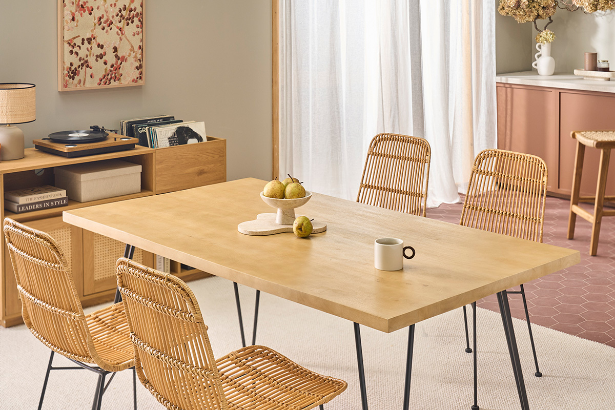 Helles Holztisch mit 4 Rattanst�hlen und Metallbeinen, Ansicht von der Seite.