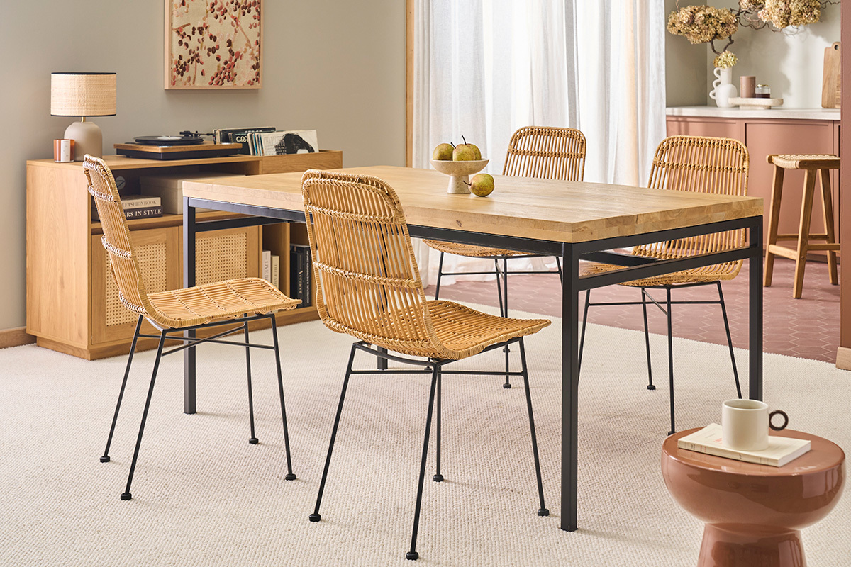 Esstisch aus Holz und Metall mit Rattanst�hlen in einem Esszimmer.