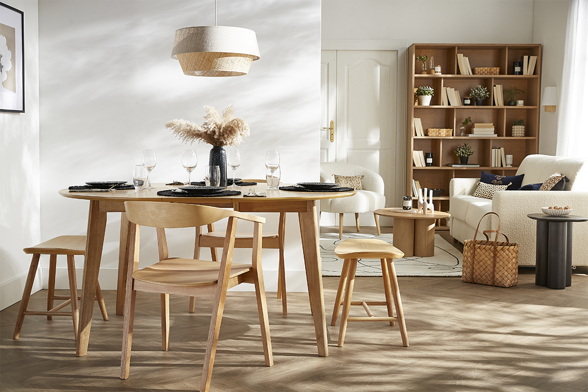 Esszimmer mit niedrigem Hocker aus hellem Holz DEMORY neben dem Tisch.