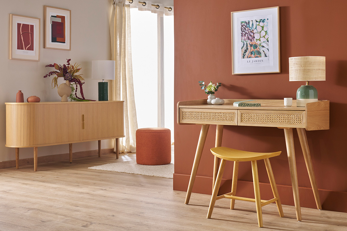 Innenraum mit niedrigem Hocker aus hellem Holz DEMORY vor einem Holzschreibtisch.