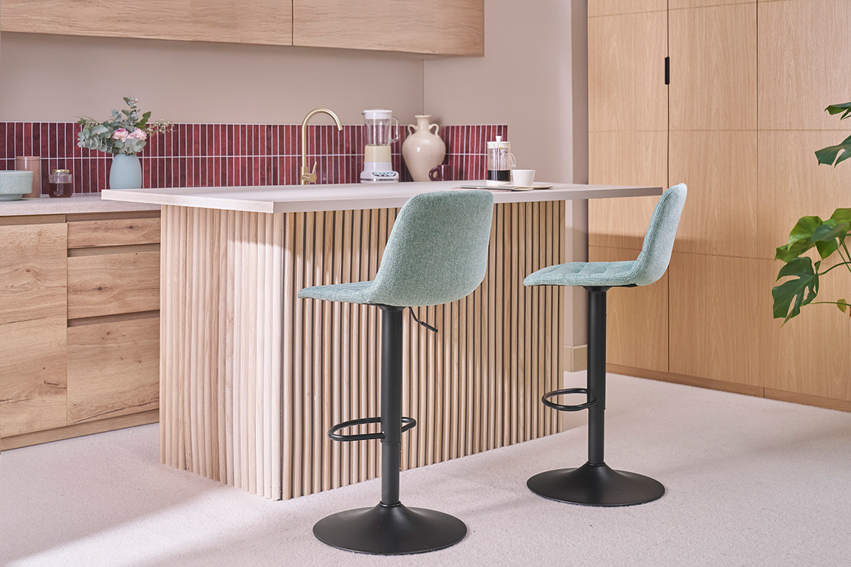 Einstellbare Celadon- und Metallhocker vor einer K�chenbar aus Holz.