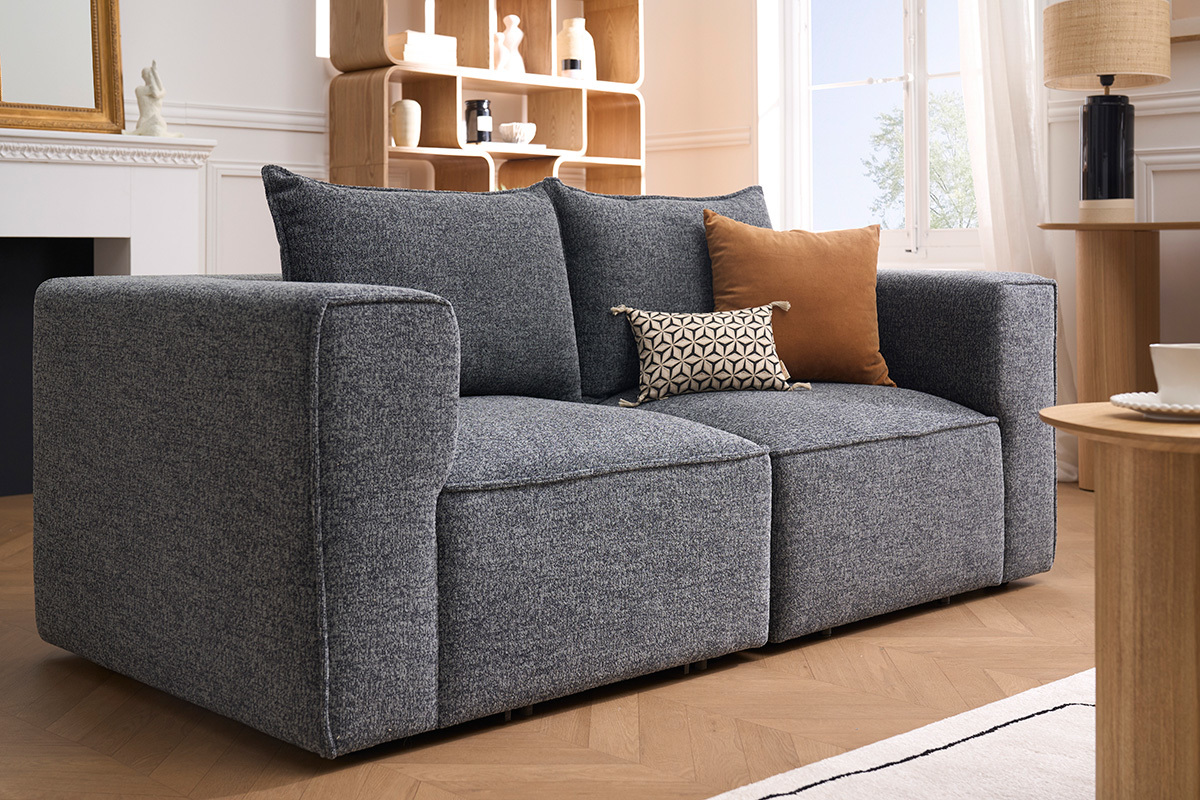 Linkes Eckmodul KERRY aus grauem Stoff, 3/4-Ansicht in einem modernen Wohnzimmer.