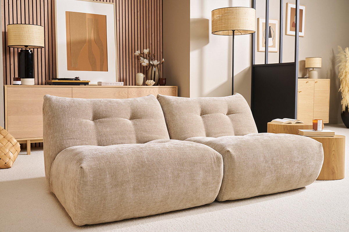 Loungesessel aus Stoff in Taupe-Velours-Optik in einem modernen Wohnzimmer.