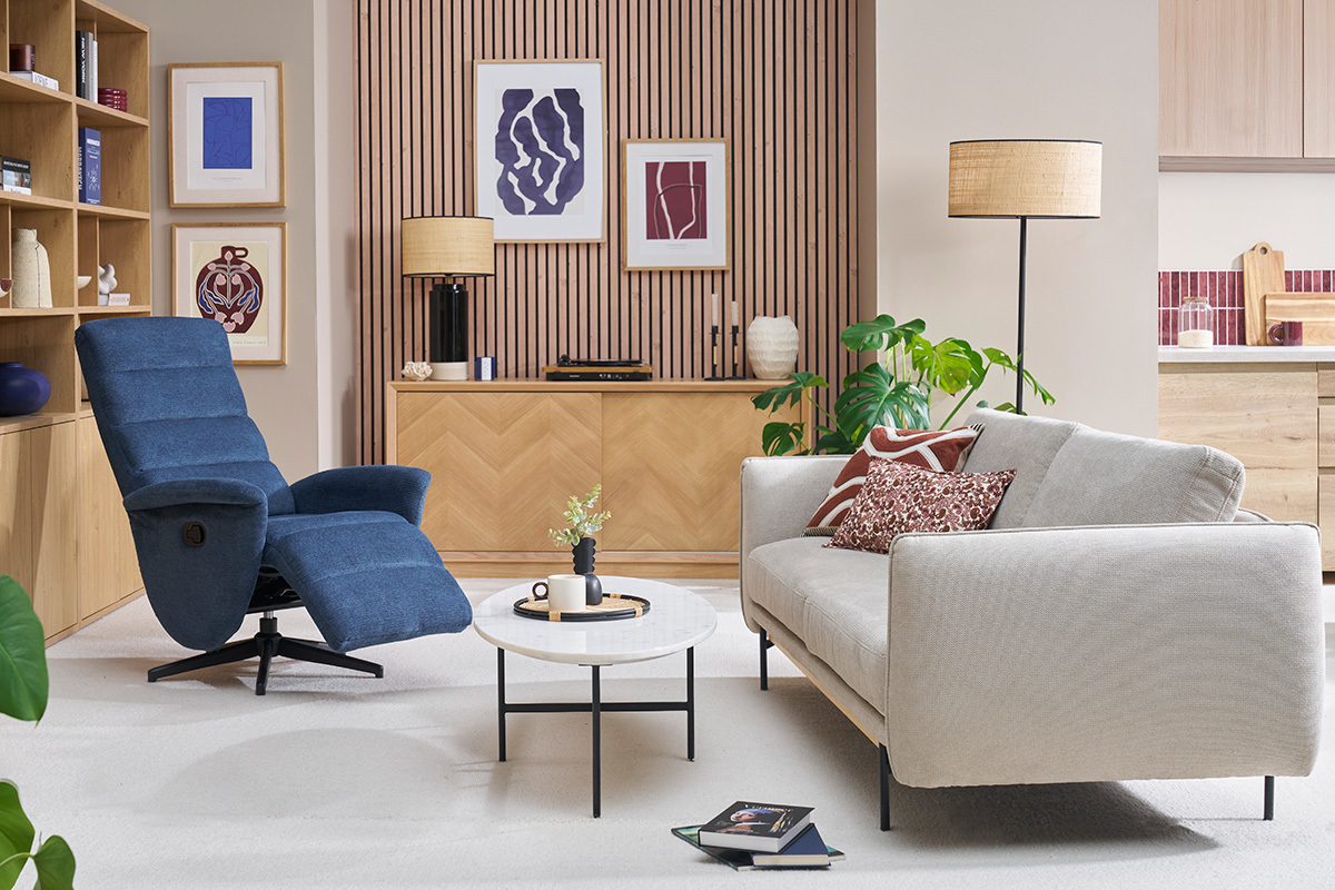 Wohnzimmer mit entspannendem, drehbarem Sessel aus blauem Stoff und hellem Sofa.