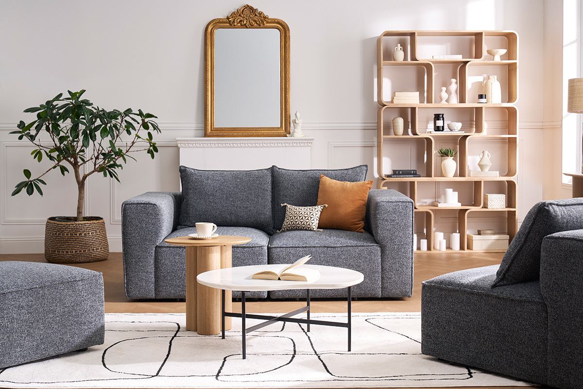Modulares 2-Sitzer-Sofa aus grauem Stoff, Vorderansicht, mit Couchtisch und zeitgen�ssischer Dekoration.