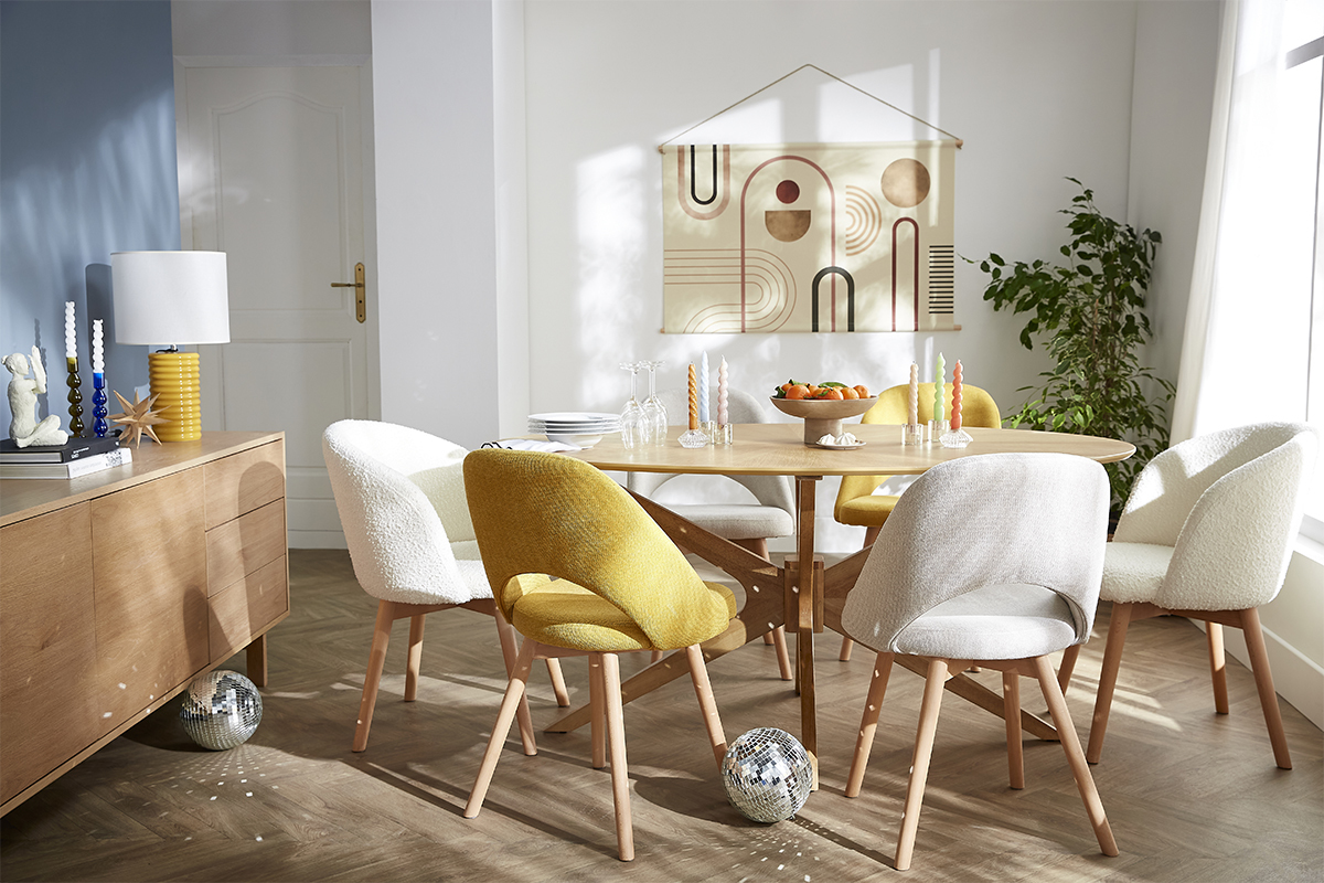 Ovaler Walnuss-Esstisch mit bunten Sthlen in einem hellen Esszimmer.