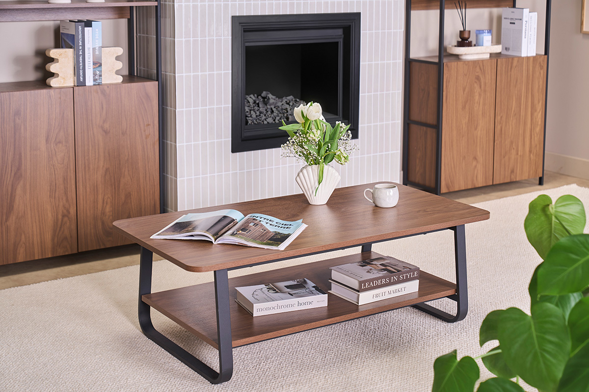 Rechteckiger Couchtisch aus Nussbaumholz und Metall mit Zeitschriften und Vase, Draufsicht.