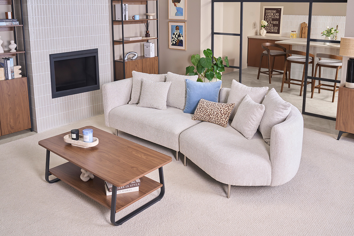 Rechteckiger Couchtisch aus Walnussholz und Metall, Seitenansicht, mit Sofa und Dekorationselementen.