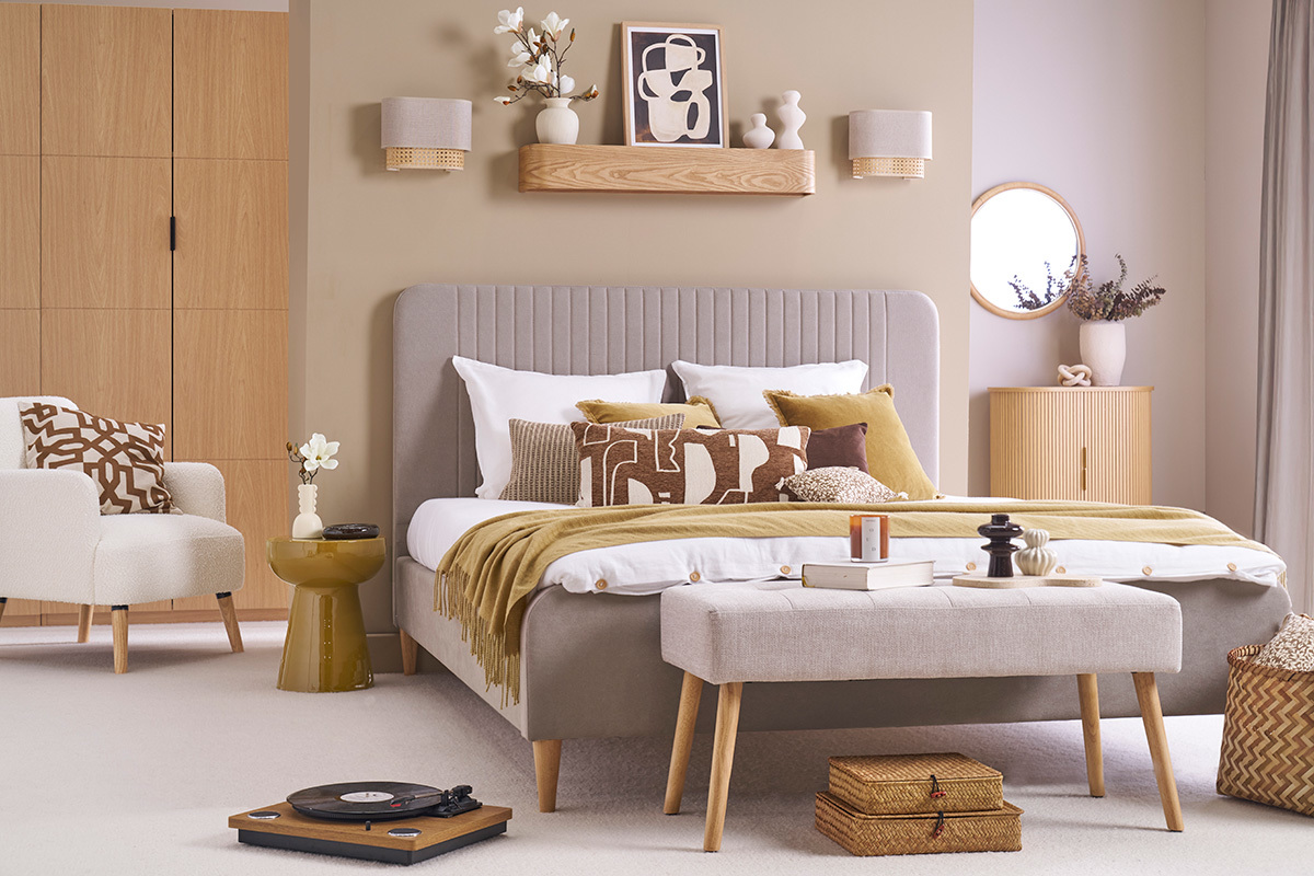Bronze-, Beige- und helles Holzschlafzimmer mit Bank und Beistelltisch in Bronze.
