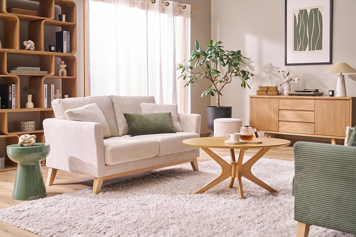 Runder Beistelltisch aus kaki-gr�nem Emaille-Metall in einem Wohnzimmer mit Sofa und Couchtisch.