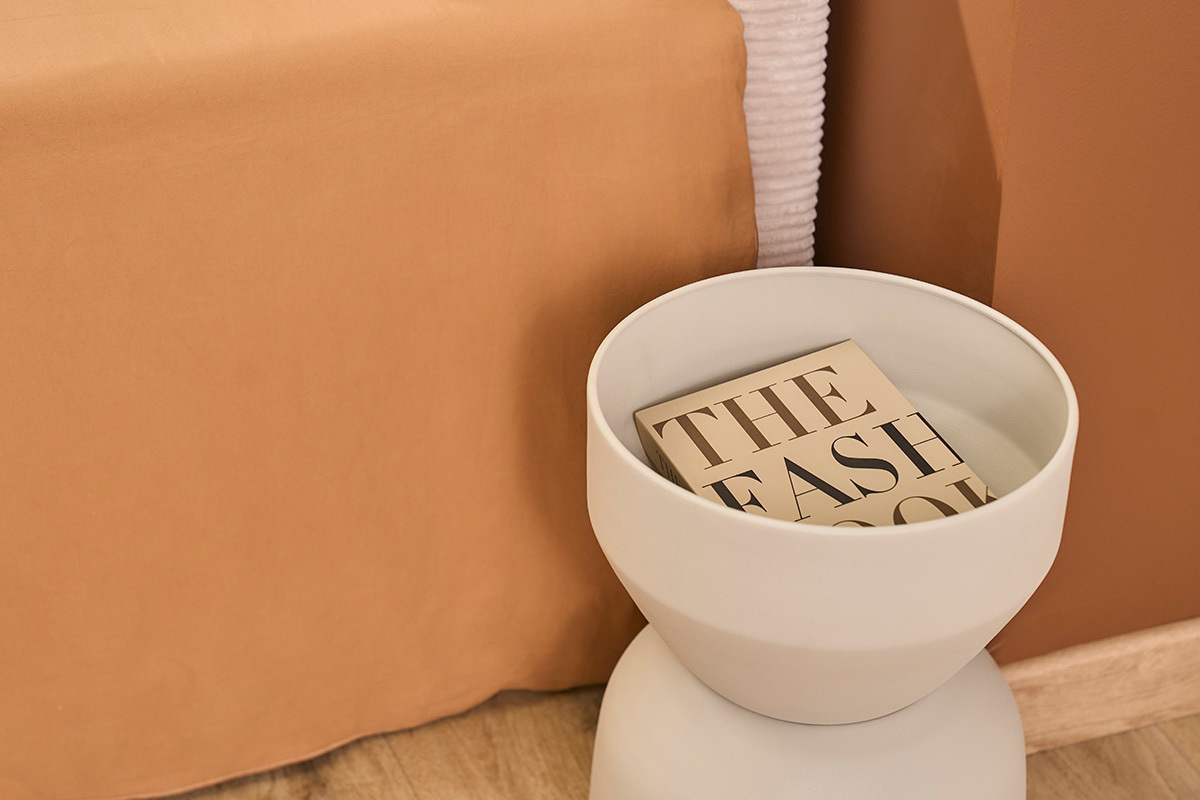 Runder Beistelltisch aus grauem Metall mit Buch, Draufsicht.