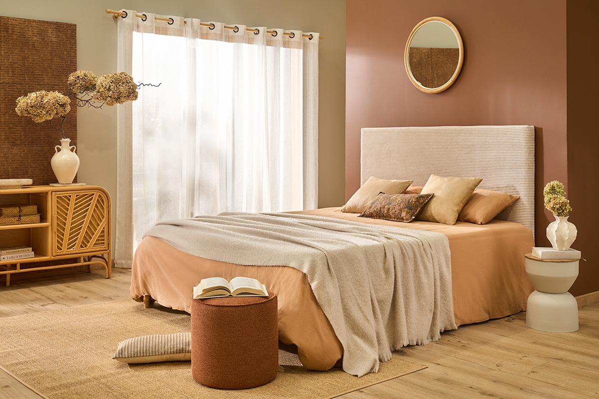 Zimmer mit einem runden YOYO Beistelltisch aus Metall und Holz neben einem Bett.